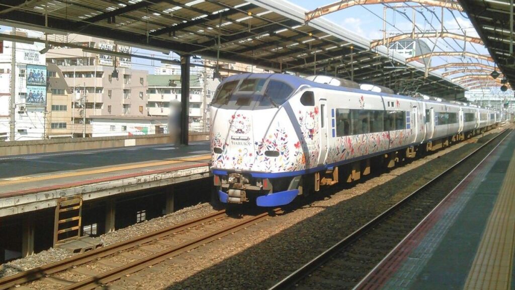 Hello Kitty Haruka wrapped train passing Shin-Imamiya Station