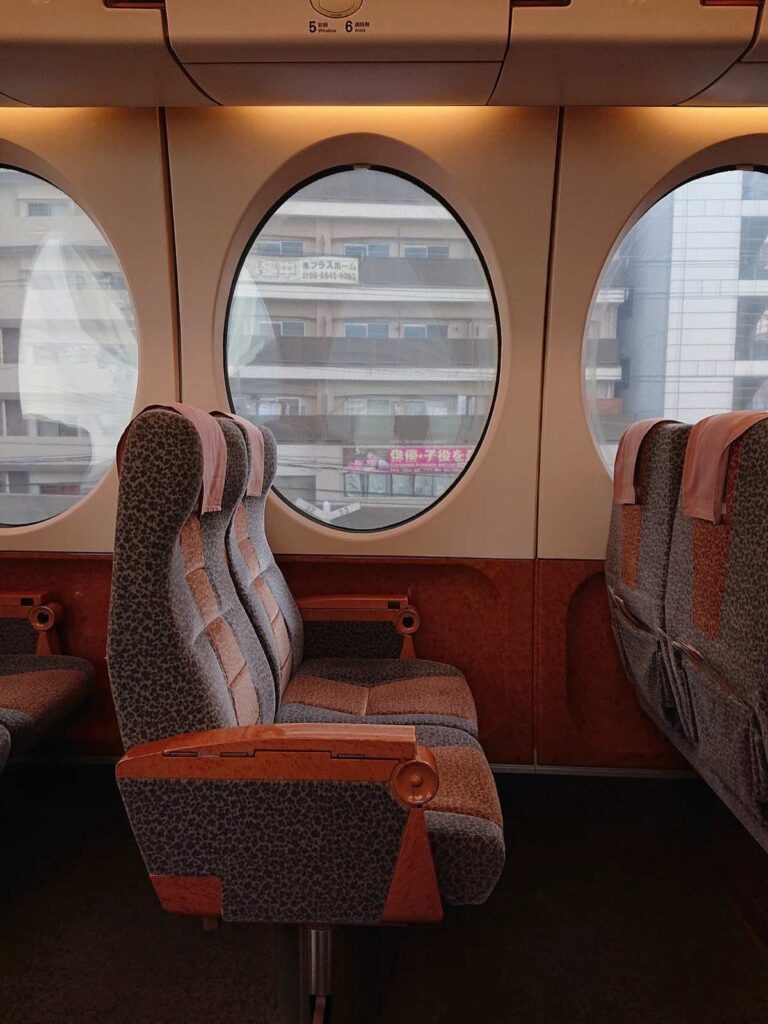 Round oval windows and seats inside the Nankai Rapi:t train