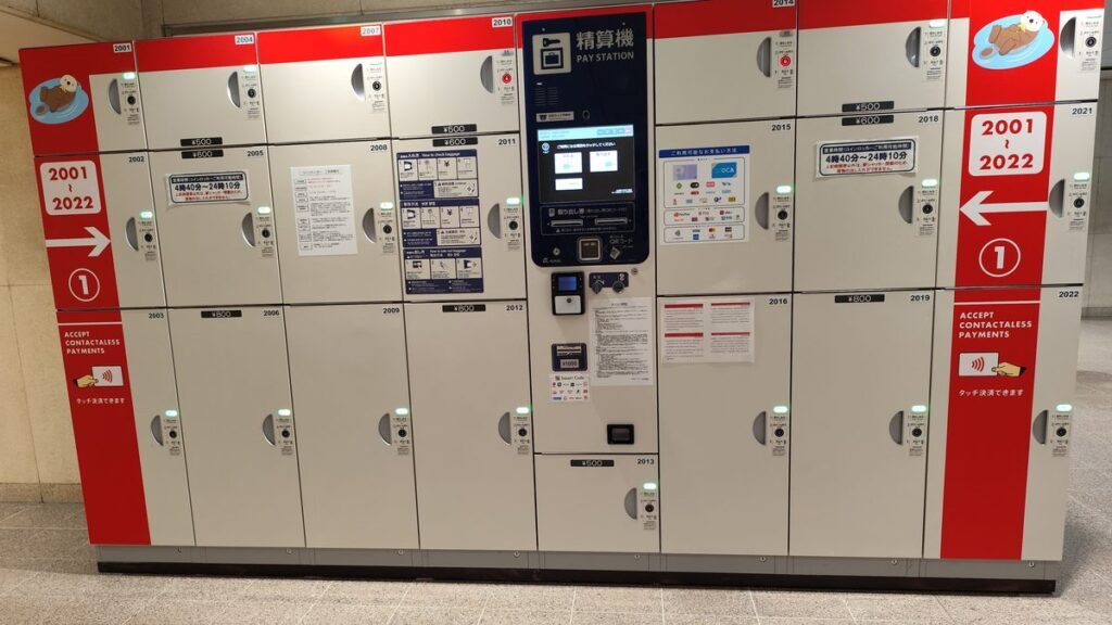 A row of coin lockers with a touchscreen pay station at JR Osaka Station